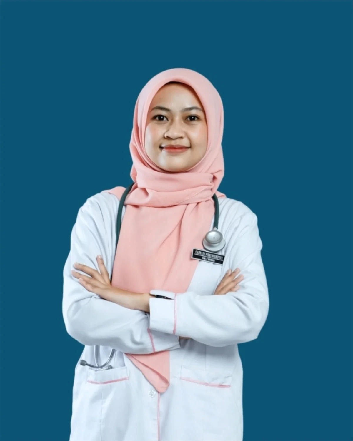 Bidan Cahyati Fitri Mumpuni, mengenakan jas praktik putih dan hijab merah muda